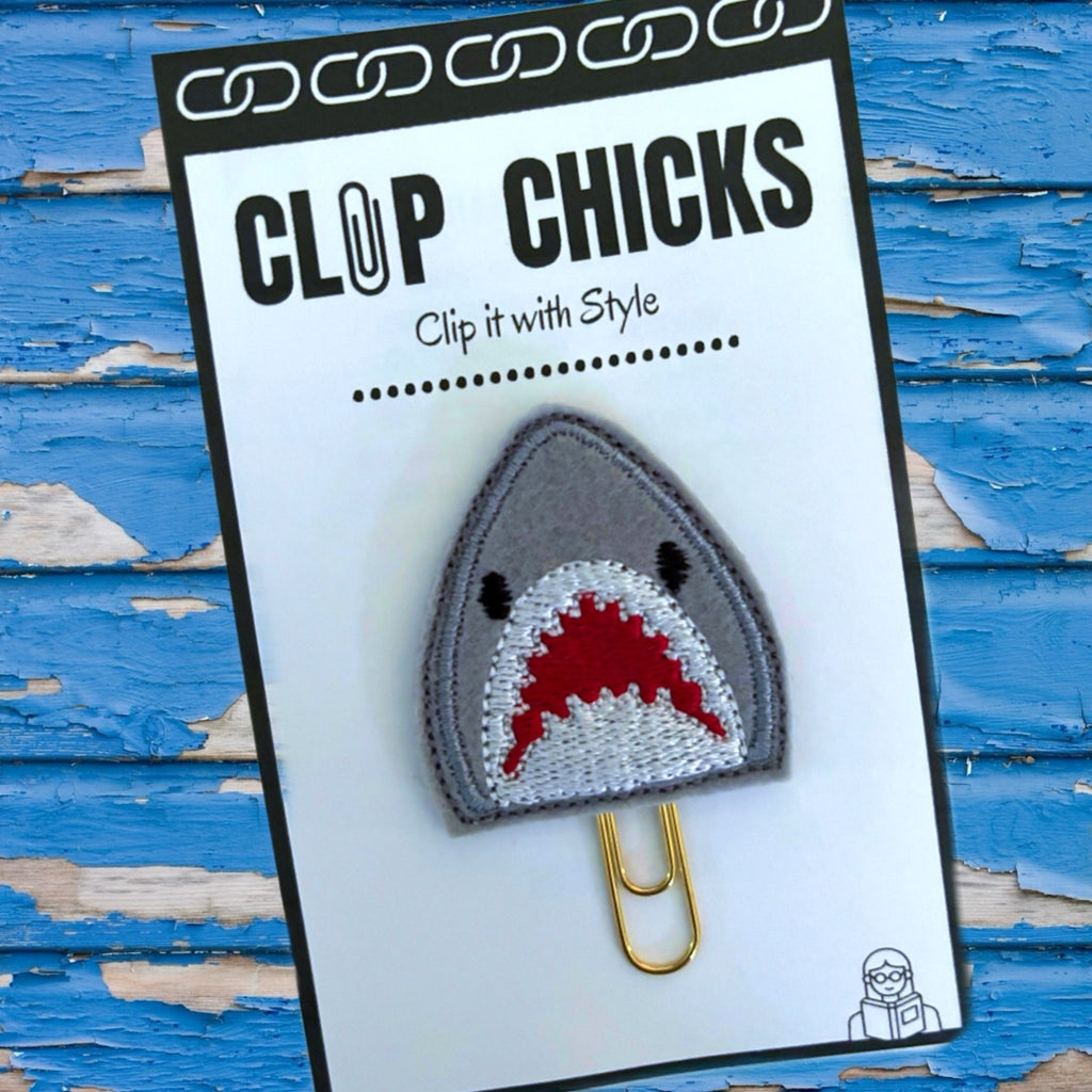 Clip Chicks novelty paper clip in the shape of a sharks with an open mouth and many teeth embroidered on is shown in its cute packaging.