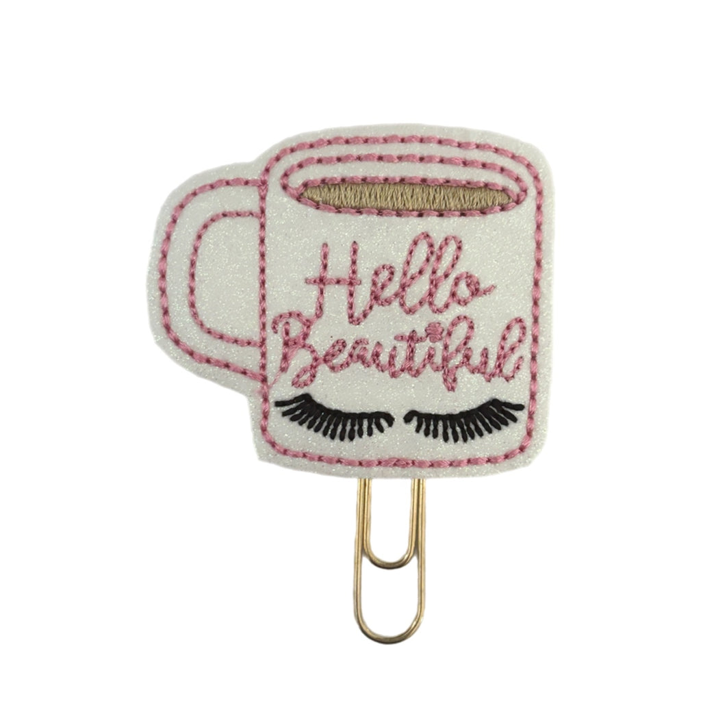 Hello Beautiful novelty paper clip from Clip Chicks, shaped like a white coffee mug with eyelashes and Hello beautiful embroidered on it.