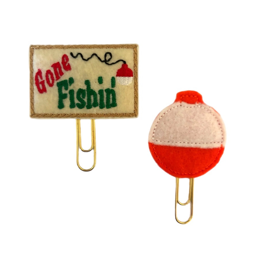 A set of two Gone Fishing novelty paper clips from Clip Chicks, with one in the shape of a bright bobber and the other with the words, Gone Fishing embroidered on it.