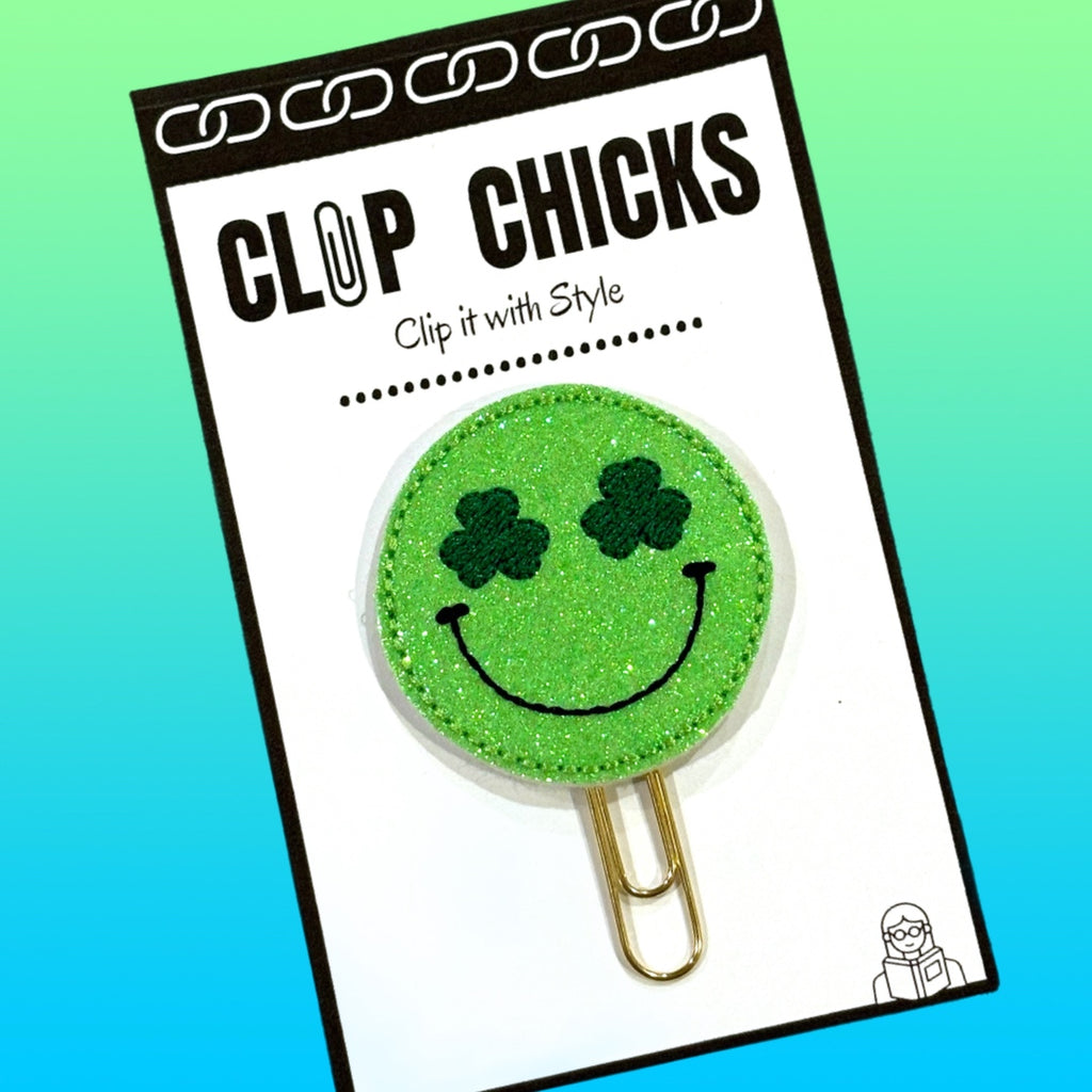 Clip Chicks' Irish Happy Face paper clip is shown in itgs package against an ombre green background.