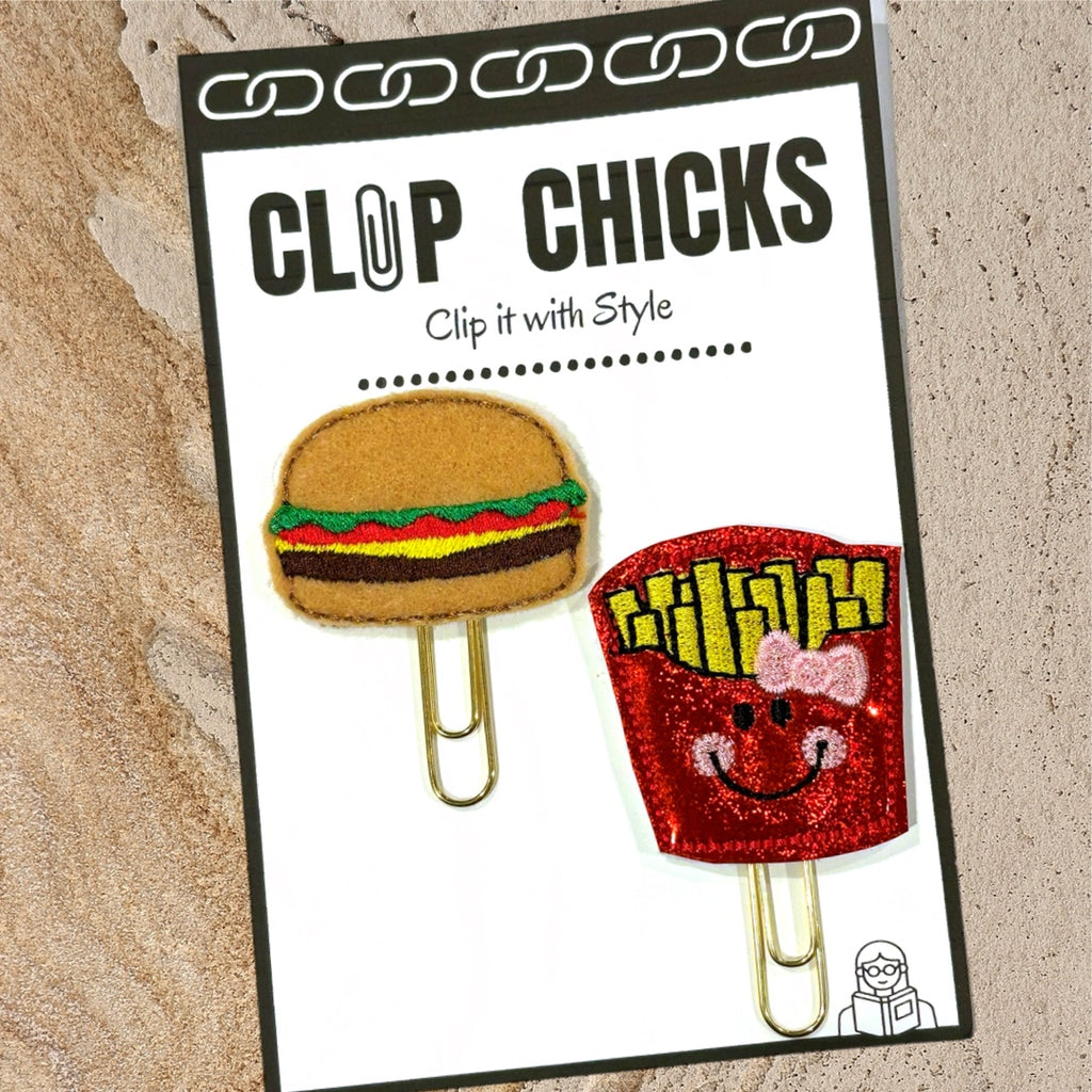 Clip Chicks package of its Burger and Fries novelty paper clips are shown against a textured beige background.