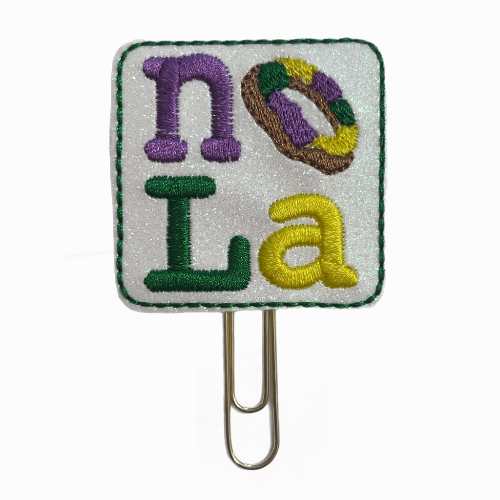 MOLA novelty paper clip from Clip Chicks LLC where the O is a King Cake, to use for Mardi Gras celebrations.