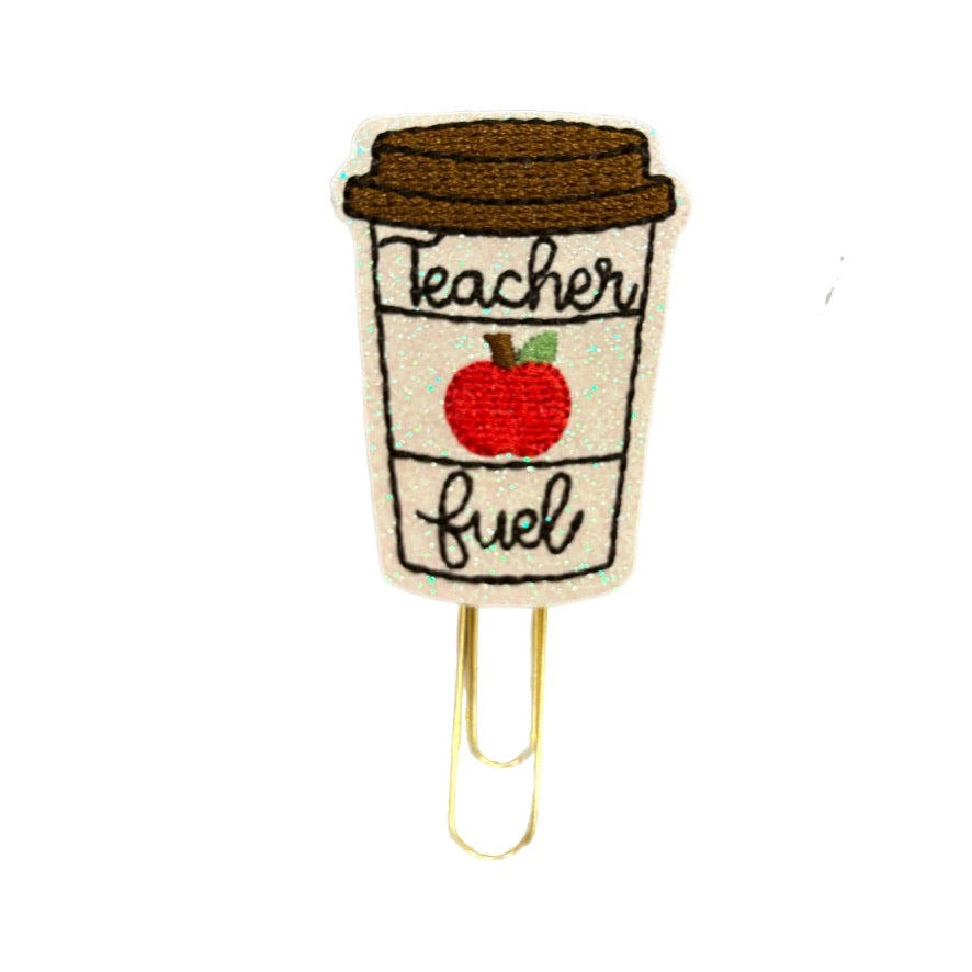 A Clip Chicks novelty paper clip is shown on a white background. Teacher Fuel and a red apple  are embroidered on the to-go shaped coffe cup, then attached to a gold toned paper clip. Great teacher's gift.