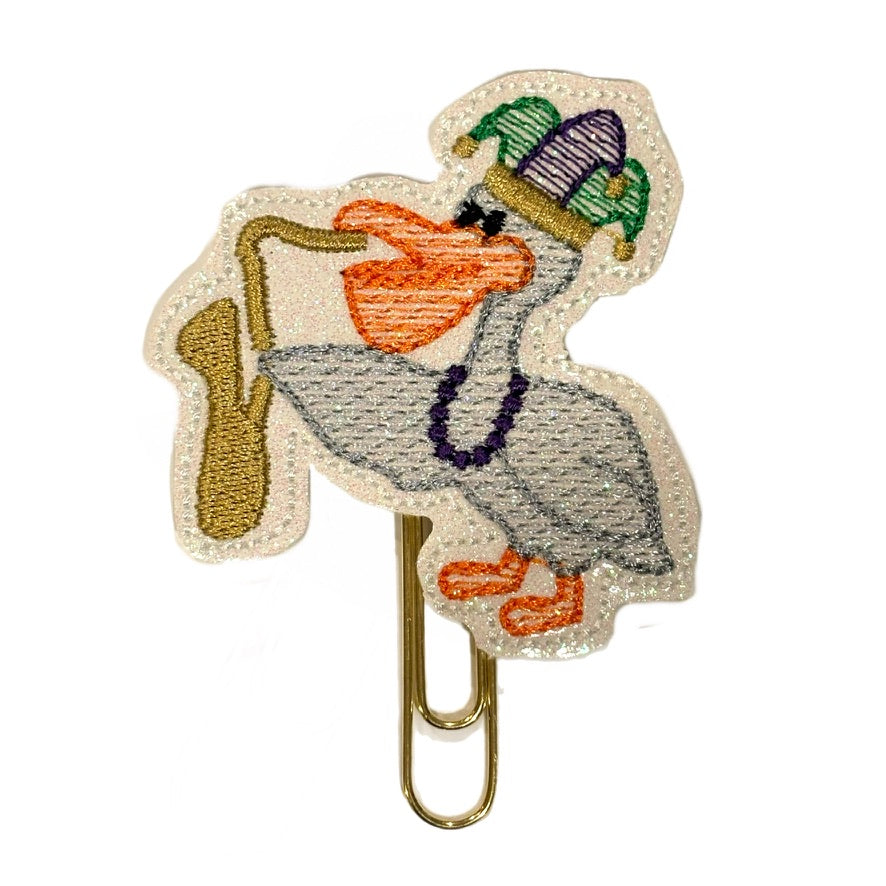 Novelty paper clip with a pelican playing a trumpet with a new orleans mardi gras hat on.