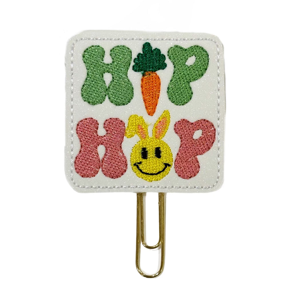 A Clip Chicks novelty paper clip shaped in a square with Hip Hop embroidered on it and a bunny and carrot.