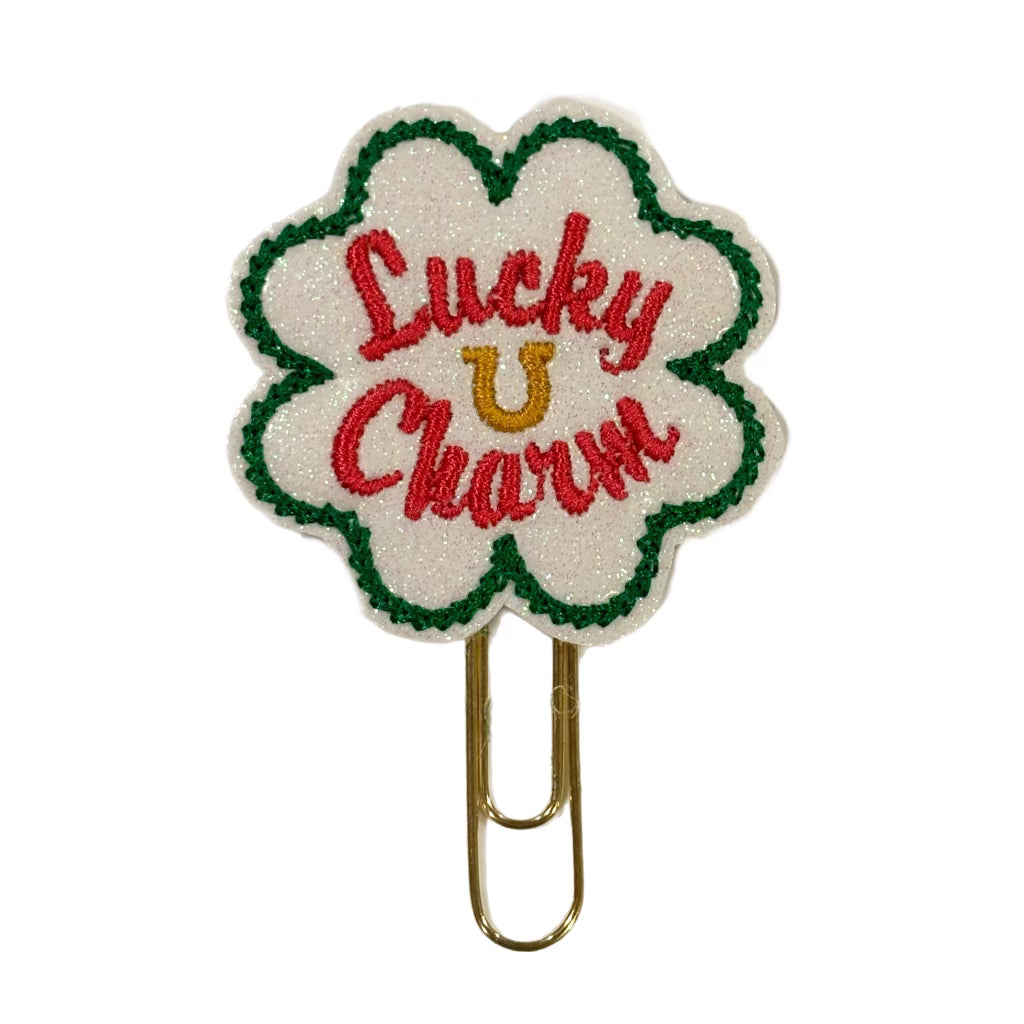 A Clip Chicks' novelty paper clip that is attched to a feltie shaped like a four leaf clover with Lucky Charm and a horseshoe embroidered on it.