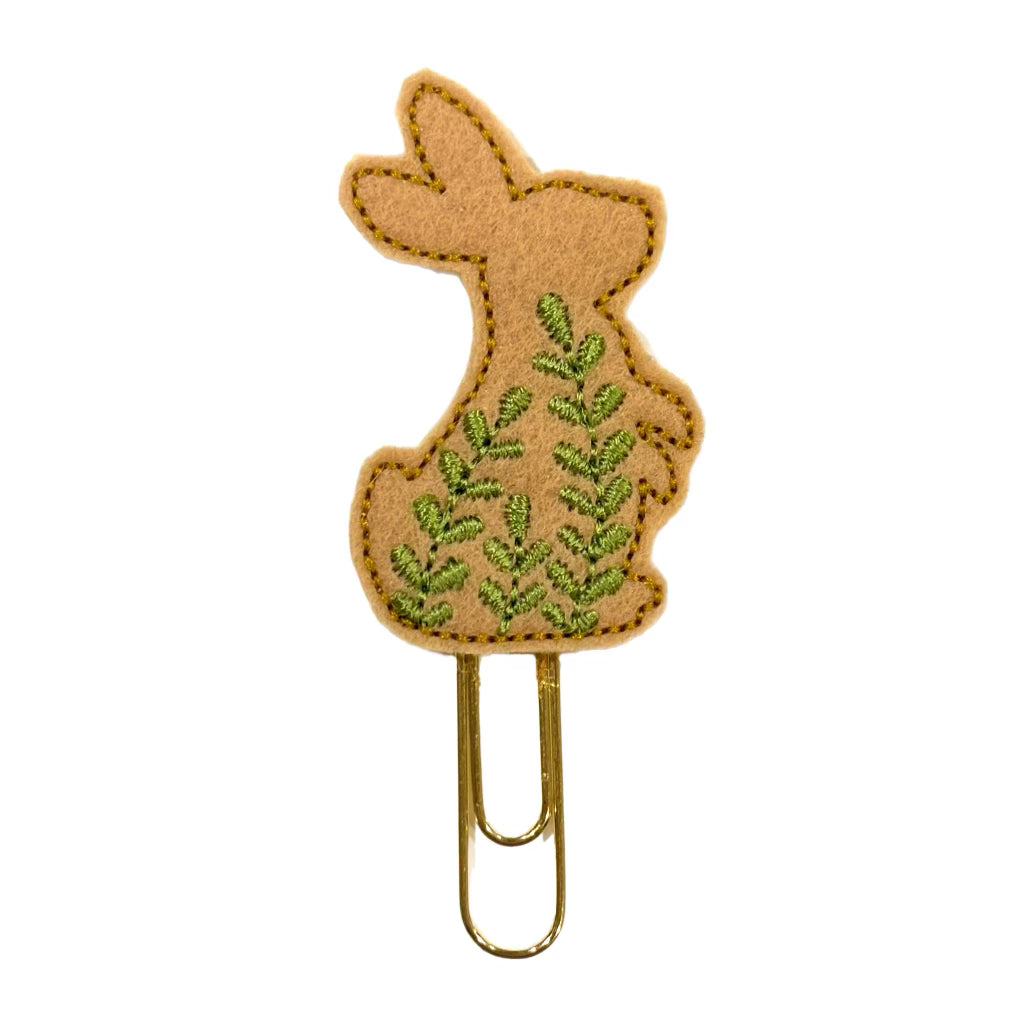 A Clip Chicks novelty paper clip shaped like a bunny standing in the grass.