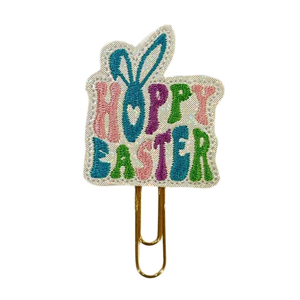 A Clip Chicks novelty paper clip shaped like a square with bunny ears coming out the top and Hoppy Easter embroidered on it.