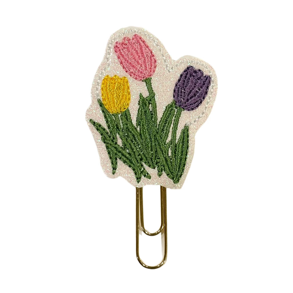 A Clip Chicks novelty paper clip shaped like three tulips growing from the ground.