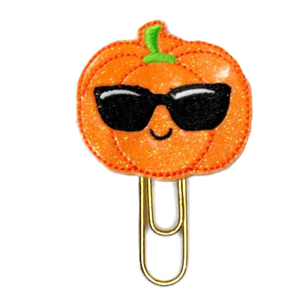 Pumpkin with black sunglasses embroidered on the glittery orange pumkin and attached to a paper clip.