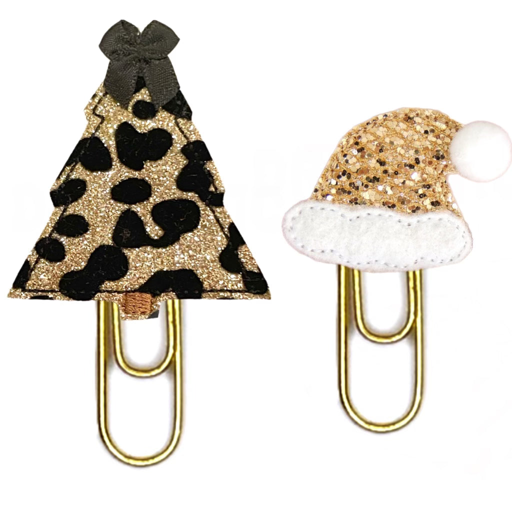 An animal print sparkly Christmas Tree novelty paper clip and a gold shimmery Santa Hat paper clip are shown from Clip chicks LLC.