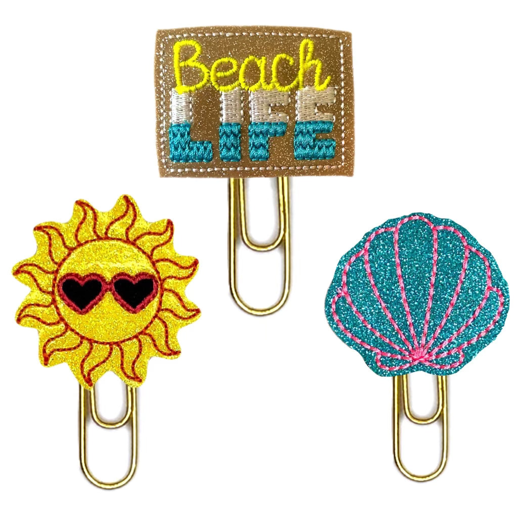 Beach Life trio of novelty paper clips from Clip chicks include one sun with sunglasses, one Beach life and one blue and pink shell.