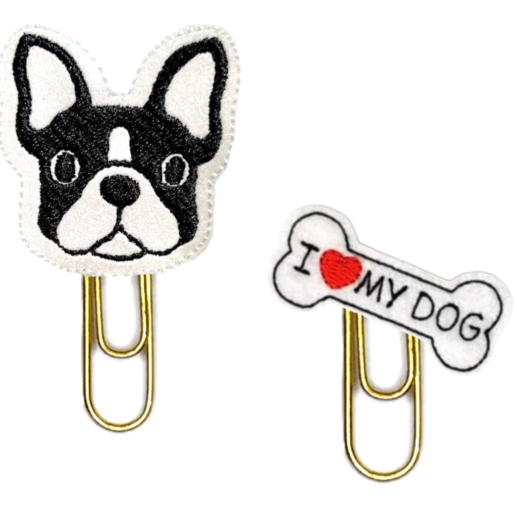 A set of two novelty paper clips , one Boston Terrier and one dog bone that reads I love my dog, are pictured on a white background.