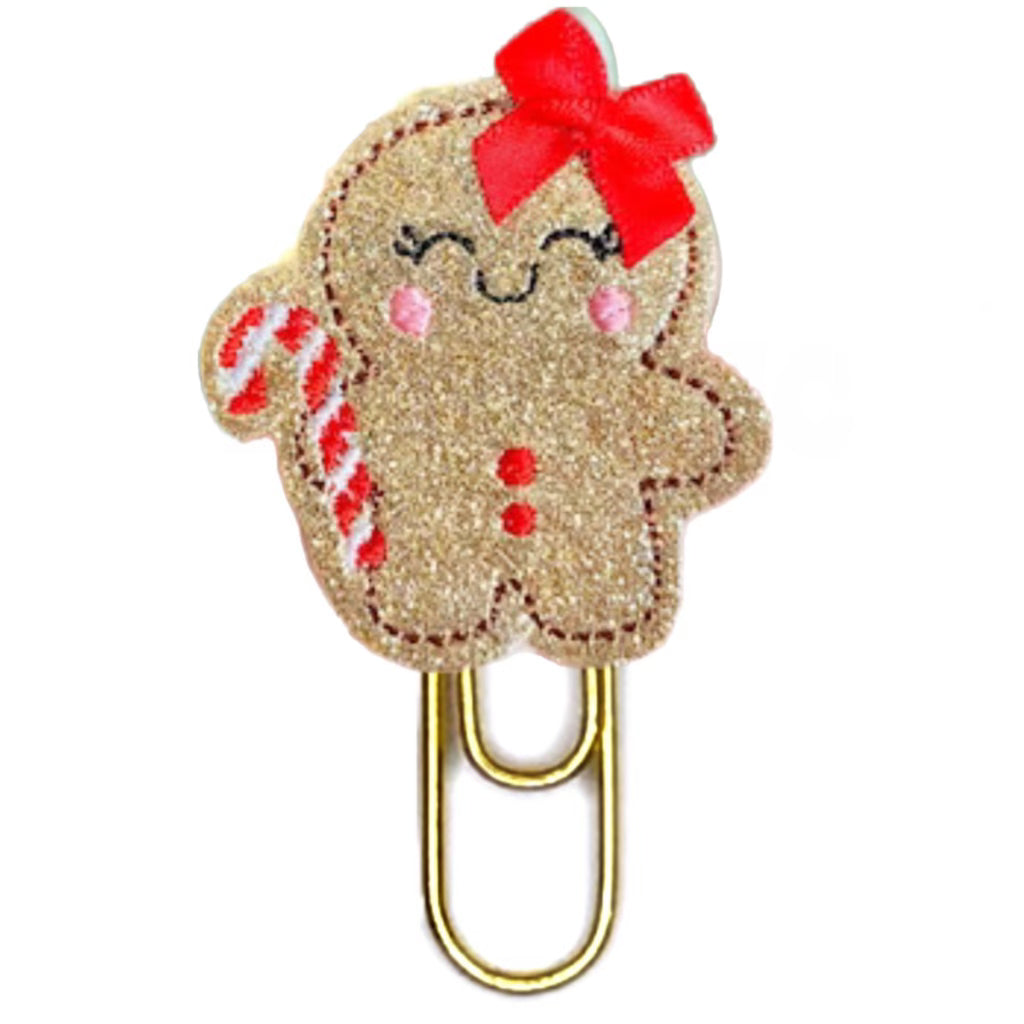 Gingerbread Girl with a red bow is a novelty paper clip.