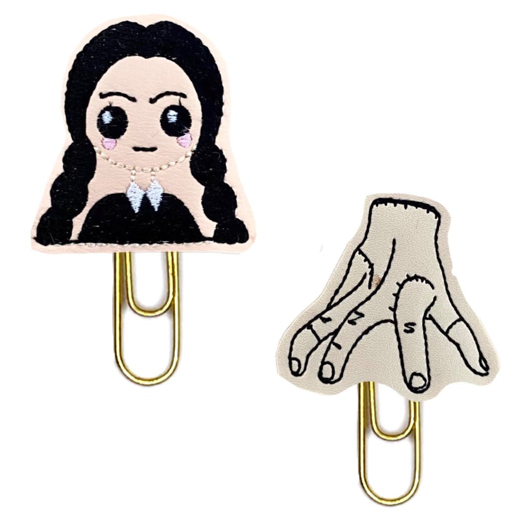 Wednesday Addams-inspired set of novelty paper clips from Clip Chicks, Goth Girl and her Thing are shown on a white background.