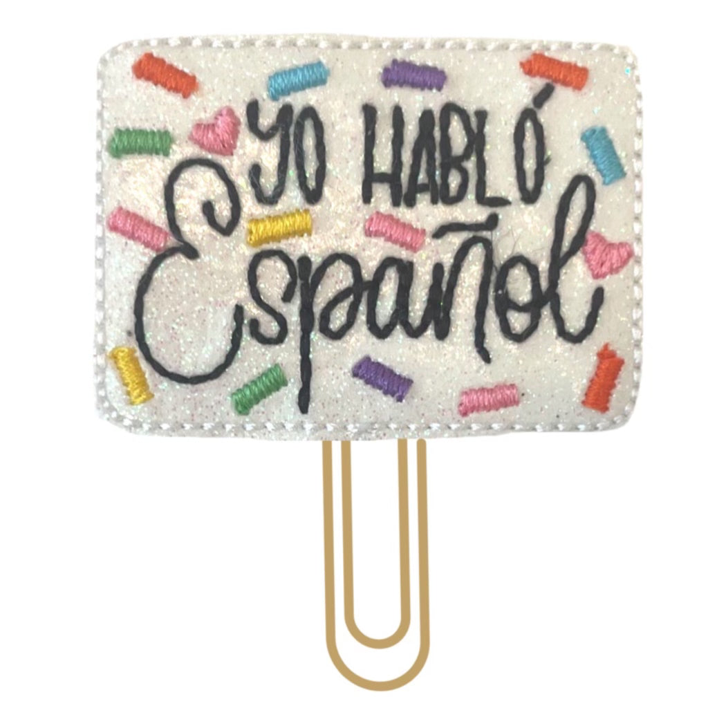 Yo Hablo Espanol or I Speak Spanish novelty paper clip from Clip Chicks is brightly embroidered and attached to a gold toned paper clip.