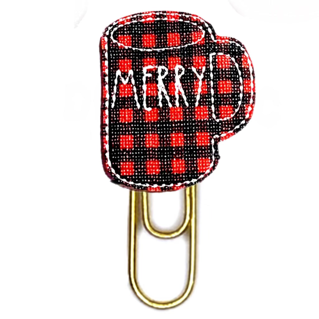 Red and Black buffalo plaid vinyl shaped like a  mug with Merry embroidered on it and attached to a paper clip.