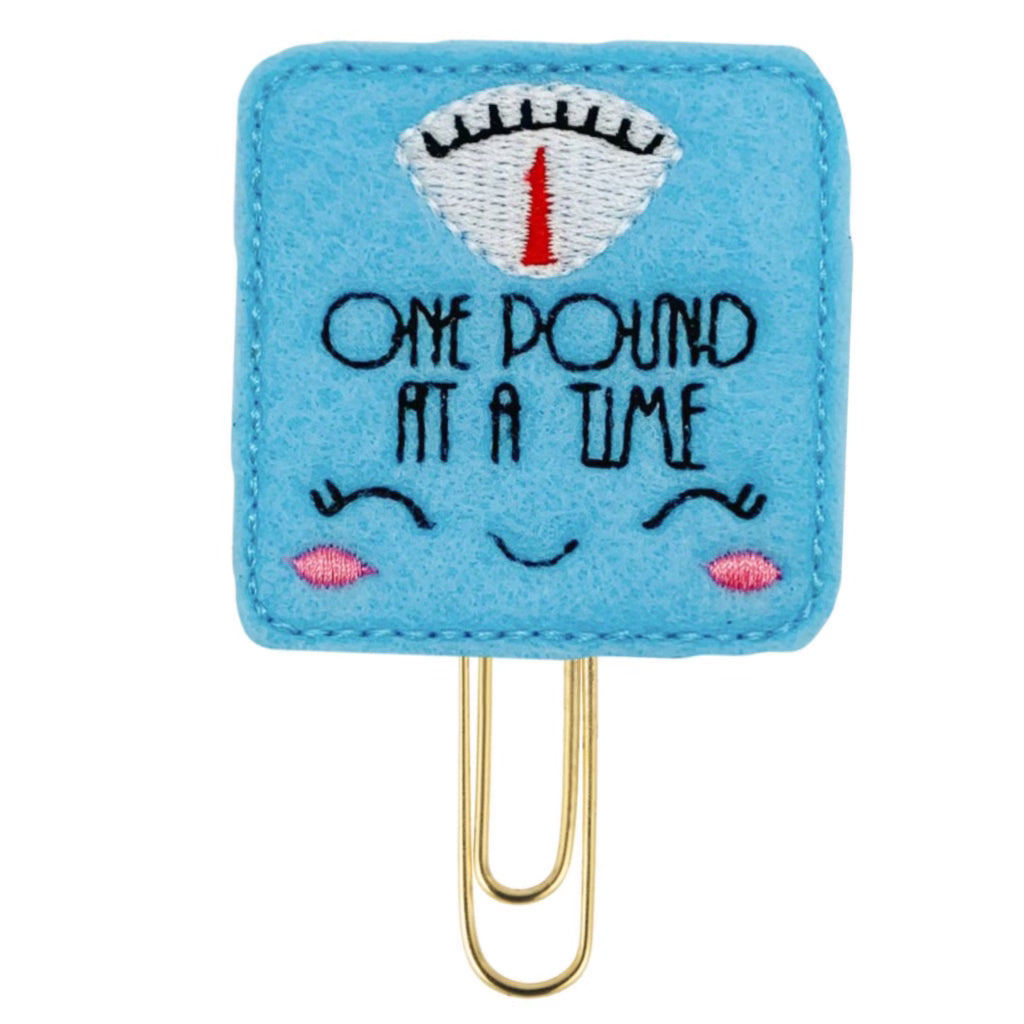 Scale novelty paper clip that says, One Pound at a Time.