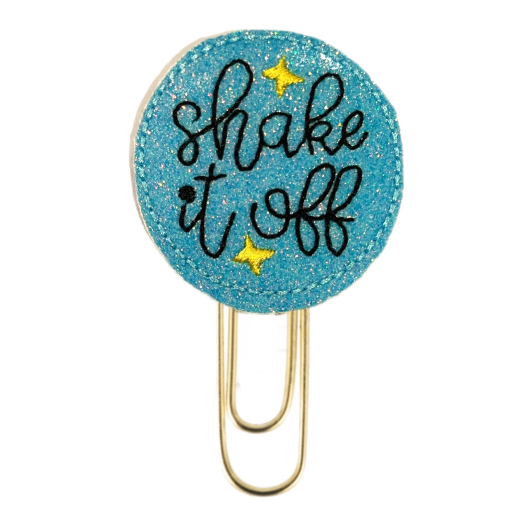 Shake It Off novelty paper clip from Clip Chicks is embroidered onto a shimmery blue circle with little yellow stars.