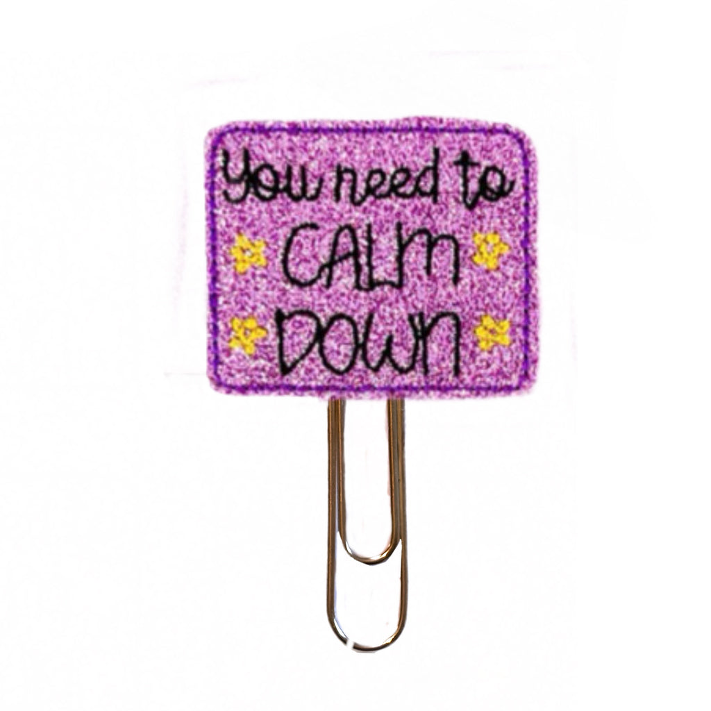 You Need To Calm Down novelty paper clip from Clip Chicks is shimmery purple with black and gold embroidery.